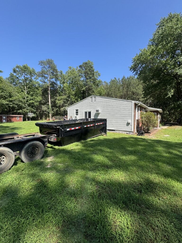 Home Wreckers Demolition and Dumpster rental truck parked beside a residential home in a green yard, showcasing a clean, driveway-friendly dumpster for easy waste disposal.
